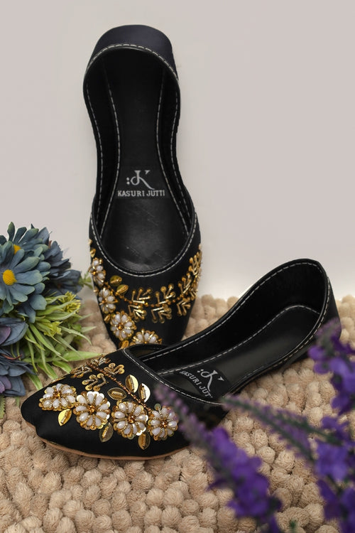 Midnight Bloom Kasuri Jutti in elegant black with opulent gold floral embroidery and pearl clusters
