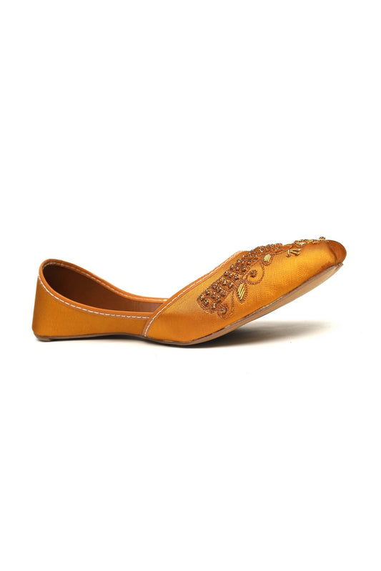 Yellow golden kasuri khussa shoe with decorative patterns on a white background, side angle