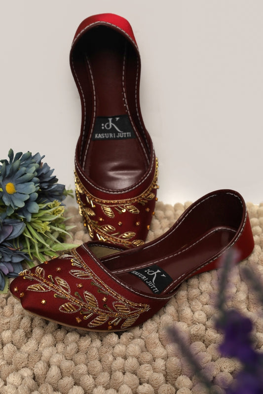 Ruby Ember Kasuri Jutti in rich maroon with golden thread and beadwork leafy design