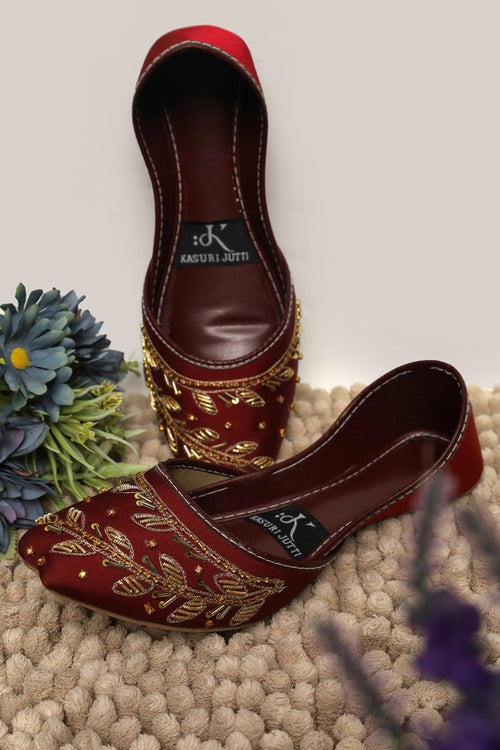Ruby Ember Kasuri Jutti in rich maroon with golden thread and beadwork leafy design