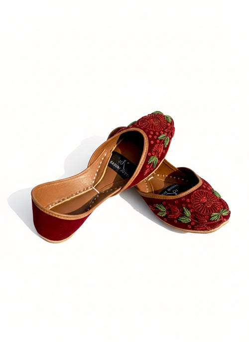 Pair of red embroidered Red Floral Kasuri Jutti on a white background