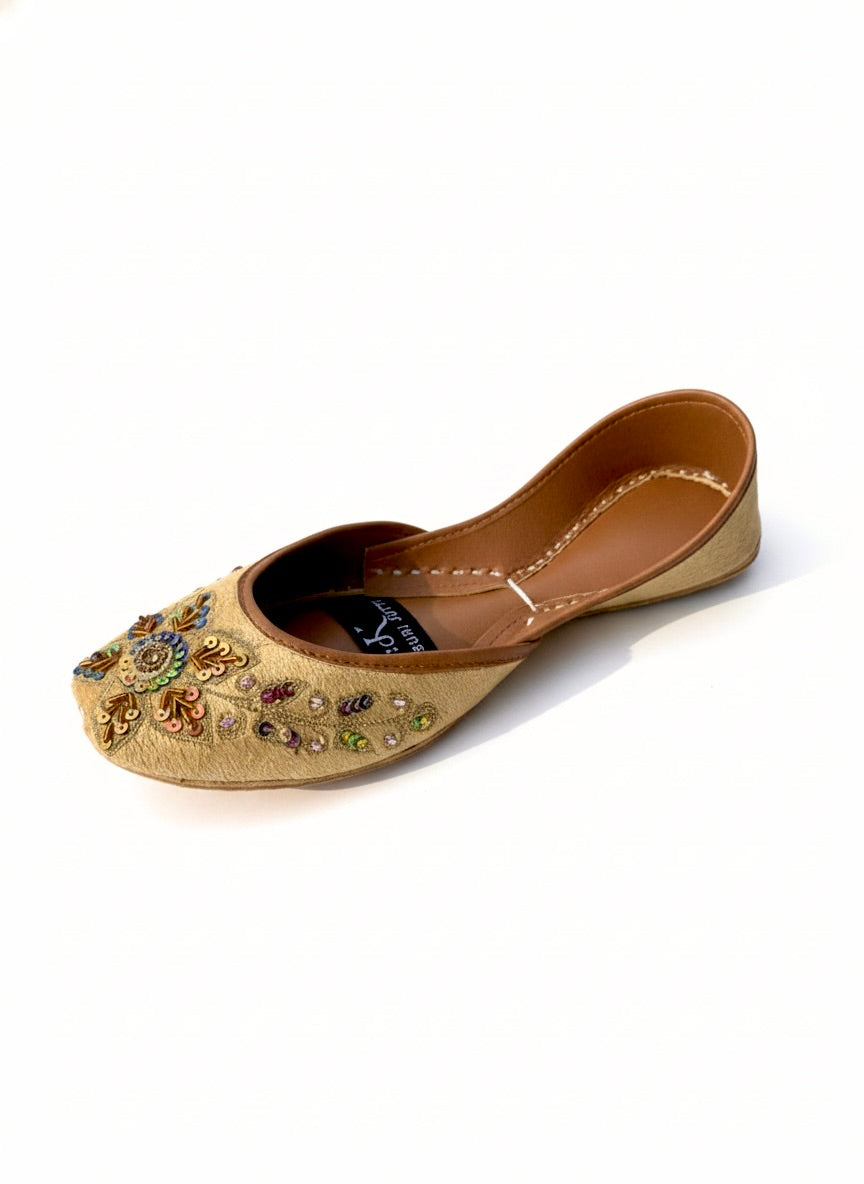 Top view of light golden Kasuri jutti with beautiful bead flowers