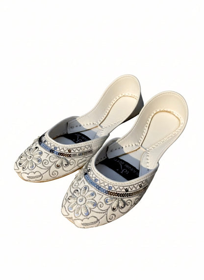 Top front view of white Kasuri jutti pair with silver flower design