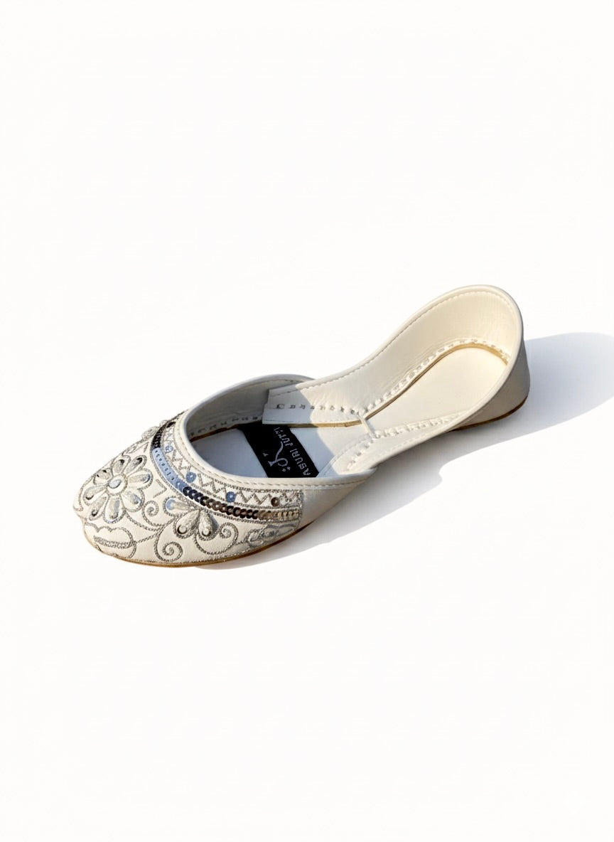 Top view of white Kasuri jutti showing silver flower and bead work